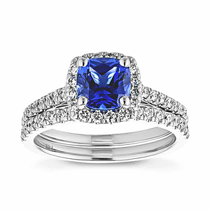  diamond halo accented engagement ring Shown with a 1.0ct Cushion cut Blue Sapphire Gemstone with a diamond accented halo and diamonds accenting the band in recycled 14K white gold with matching band