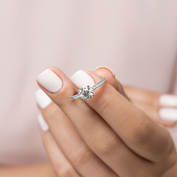 Shown with 1ct Round Cut Lab Grown Diamond in 14k White Gold|Stunning stackable diamond accented solitaire engagement ring with 1ct round cut lab grown diamond in 14k white gold held in hand