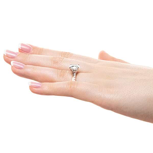 Pave set diamond accented engagement ring with asymmetrical design set with 1.5ct oval cut lab grown diamond center stone in 14k rose gold band worn on hand sideview