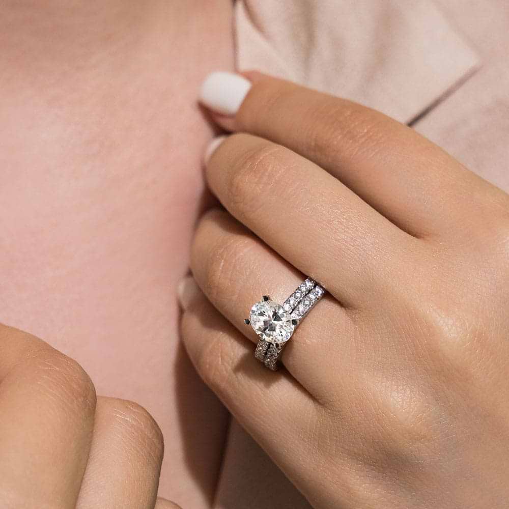 Shown with a 3.2ct Oval cut Lab-Grown Diamond with a diamond accented band in recycled 14K white gold with matching band, can be purchased as a set at a discounted price 