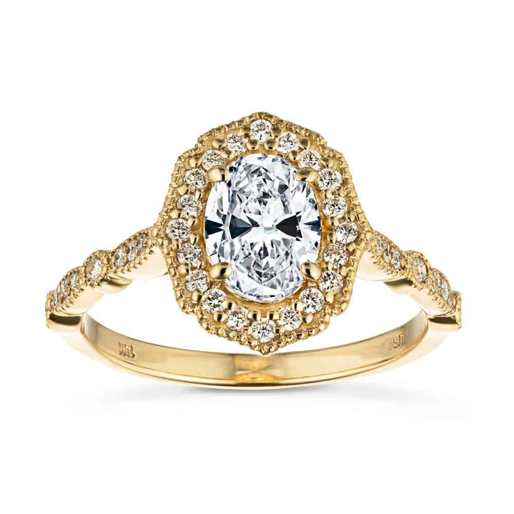 Shown with 1ct Oval Cut Lab Grown Diamond in 14k Yellow Gold|Romantic vintage style diamond accented halo engagement ring with a 1ct oval cut lab grown diamond set in filigree and milgrain detailed 14k yellow gold band
