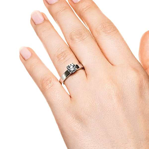 Modern solitaire engagement ring with 1ct round cut lab grown diamond in thick 14k white gold band worn on hand