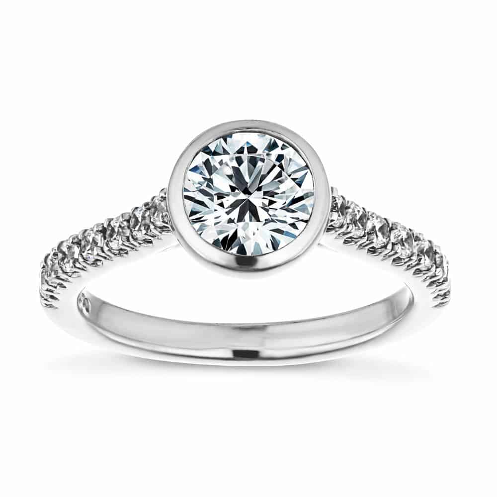 Shown with a bezel set 1.0ct Round cut Lab-Grown Diamond with accenting stones on the band in recycled 14K white gold | stackable engagement ring Shown with a bezel set 1.0ct Round cut Lab-Grown Diamond with accenting stones on the band in recycled 14K white gold
