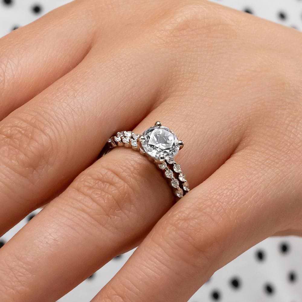 Shown with a 1.0ct Round cut Lab-Grown Diamond with accenting diamonds on the band in recycled 14K white gold with matching wedding band, can be purchased together for a discounted price 