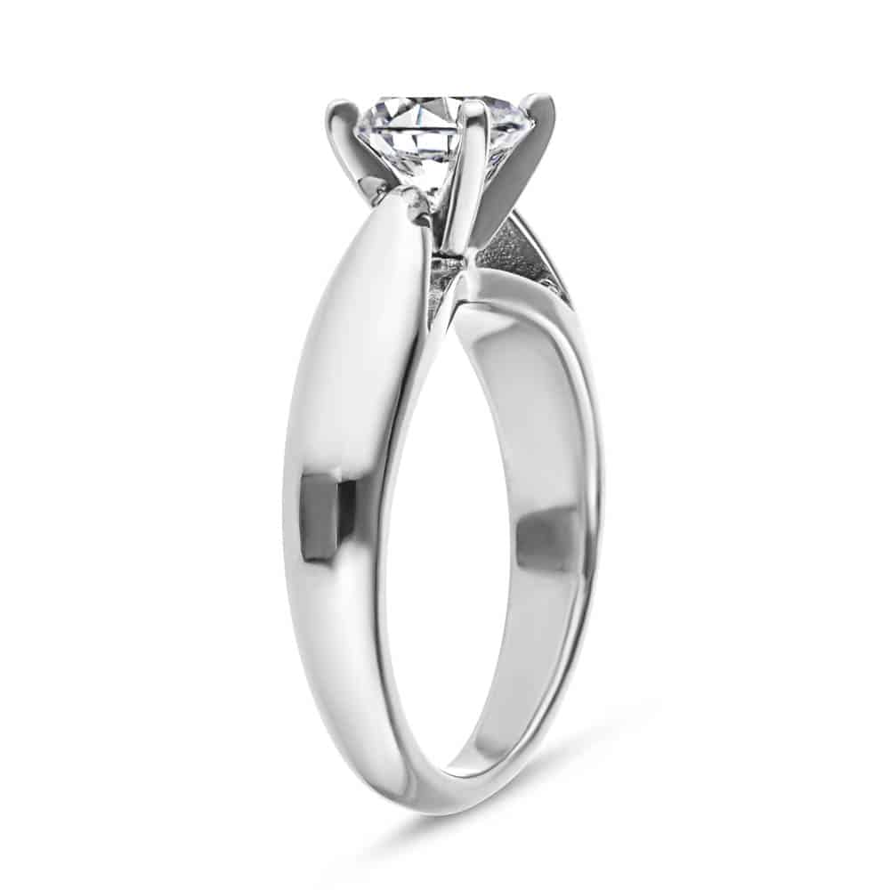 Shown with 1ct Round Cut Lab Grown Diamond in Platinum|Modern solitaire engagement ring with wide band and cathedral style design featuring 1ct round cut lab grown diamond in platinum shown from side