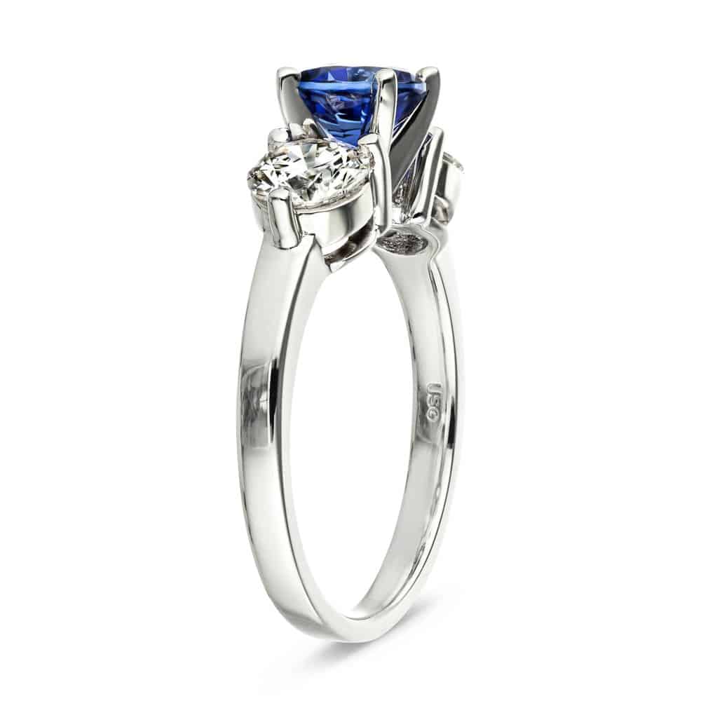Shown with Round Cut Lab Grown Diamonds on either side of a Lab Created Blue Sapphire in 14k White Gold|Three stone engagement with round cut lab grown diamonds and lab created blue sapphire center stone in 14k white gold side view