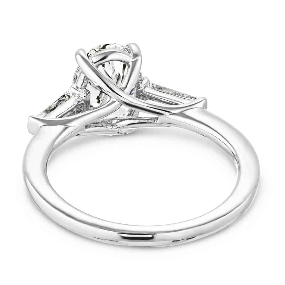 Shown with 2ct Oval Cut Lab Grown Diamond set in 14k White Gold|Beautiful three stone engagement ring with trellis set 2ct oval cut lab grown diamond amid baguette side stones in 14k white gold shown from back