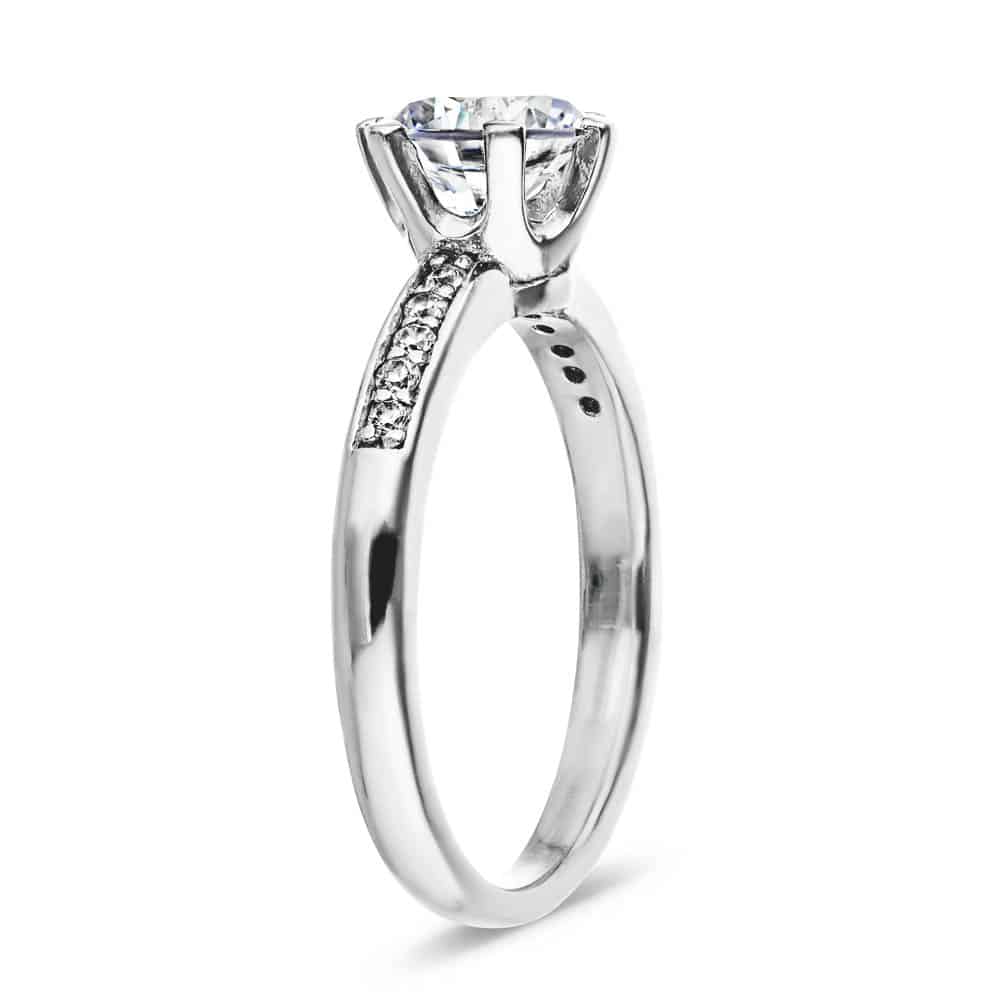 Shown with 1ct Round Cut Lab Grown Diamond in 14k White Gold|Channel set diamond accented engagement ring with 1ct round cut lab grown diamond in 14k white gold shown from side