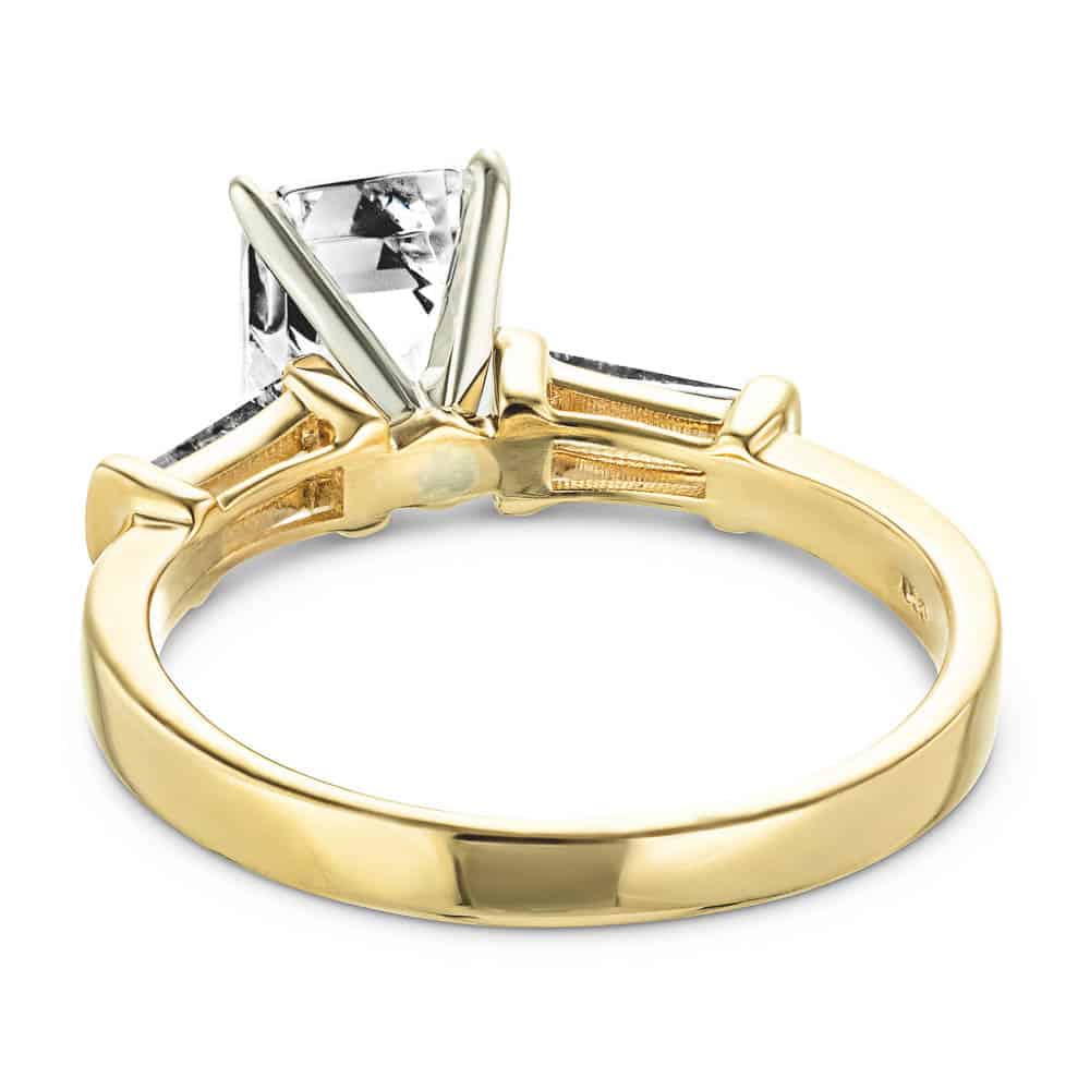Shown with 1.5ct Emerald Cut Lab Grown Diamond in 14k Yellow Gold|Modern three stone engagement ring with two baguette cut recycled diamond side stones and a 1.5ct emerald cut lab grown diamond center in 14k yellow gold shown from back