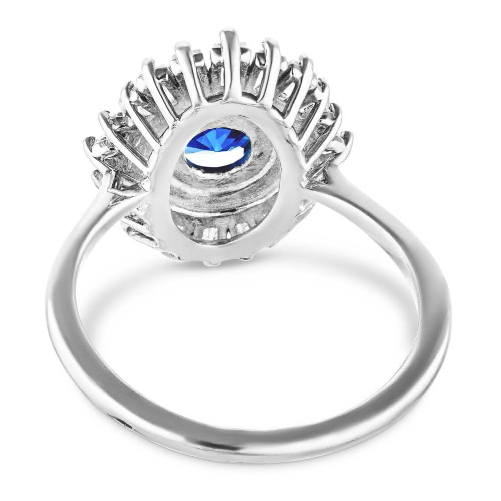 Shown with 1ct Round Cut Lab Grown Blue Sapphire|Vintage style diamond halo engagement ring with baguette cut diamonds surrounding a 1ct round cut lab grown blue sapphire in 14k white gold shown from back