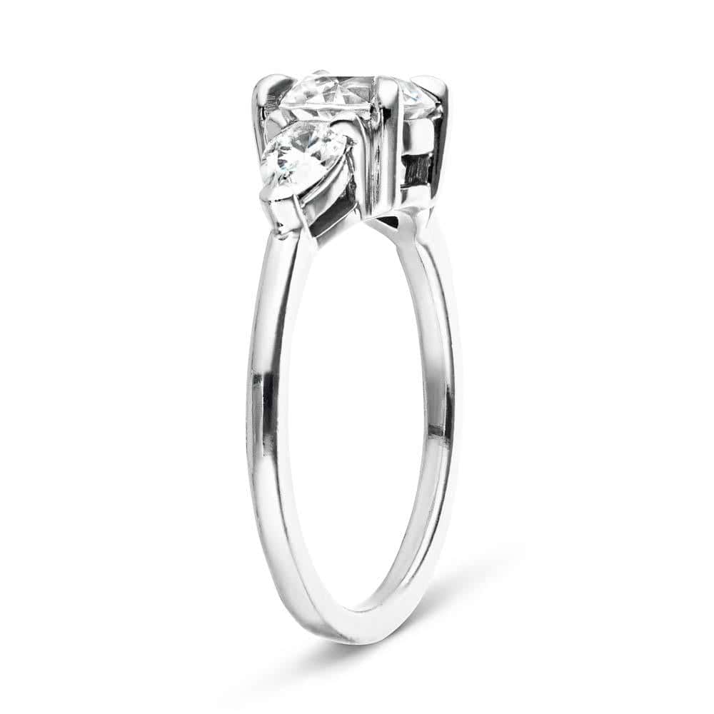Shown with 1ct Round Cut Lab Grown Diamond Center Stone in 14k White Gold|Three stone engagement ring with 1ct round cut lab grown diamond center and 0.5ct pear cut diamond side stones in 14k white gold shown on side