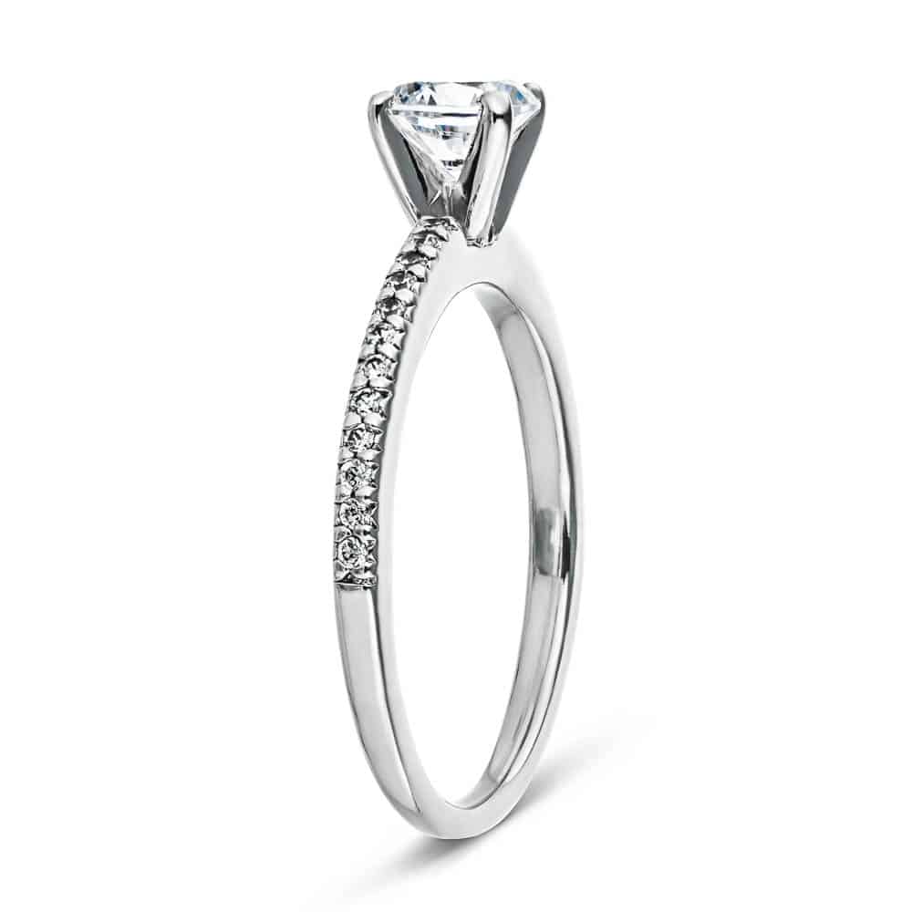 Shown with 0.70ct Round Cut Lab Grown Diamond in 14k White Gold|Diamond accented solitaire engagement ring with 4 prong set round cut lab grown diamond in 14k white gold shown from side