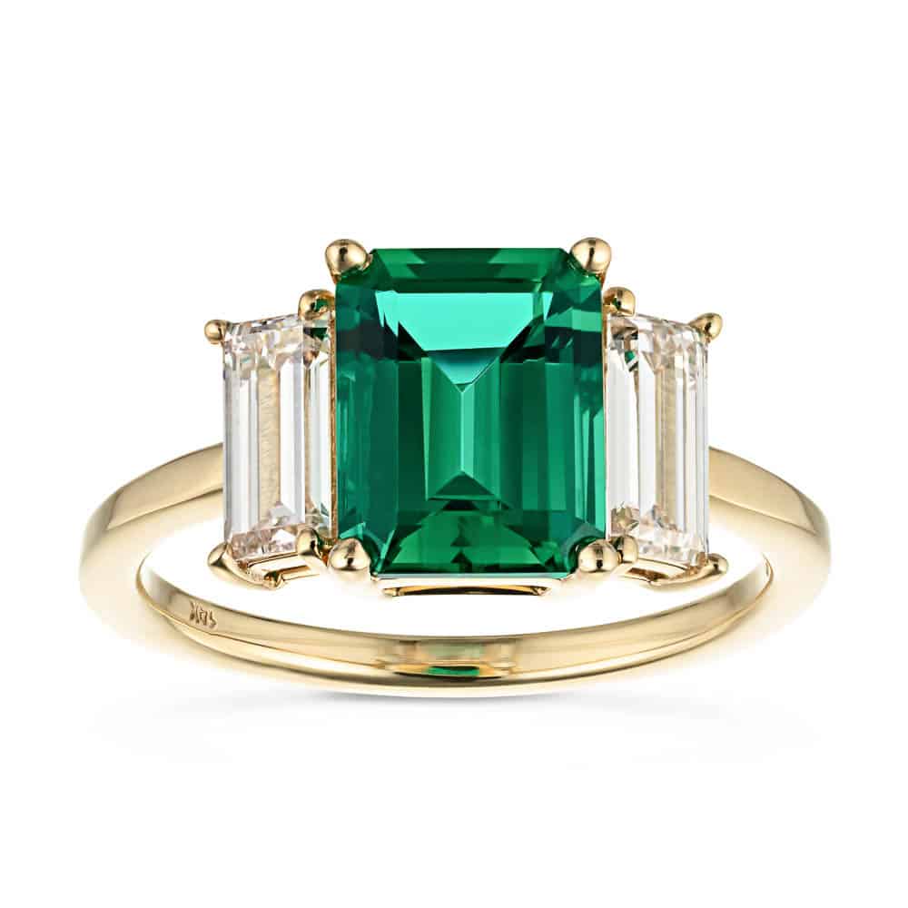 Shown with 2ct Emerald Cut Lab Grown Emerald with 2 Baguette Cut Lab Diamonds in 14k Yellow Gold|Stunning ethical three stone engagement ring with 2ct emerald cut lab created emerald center between baguette cut lab diamonds set in 14k yellow gold