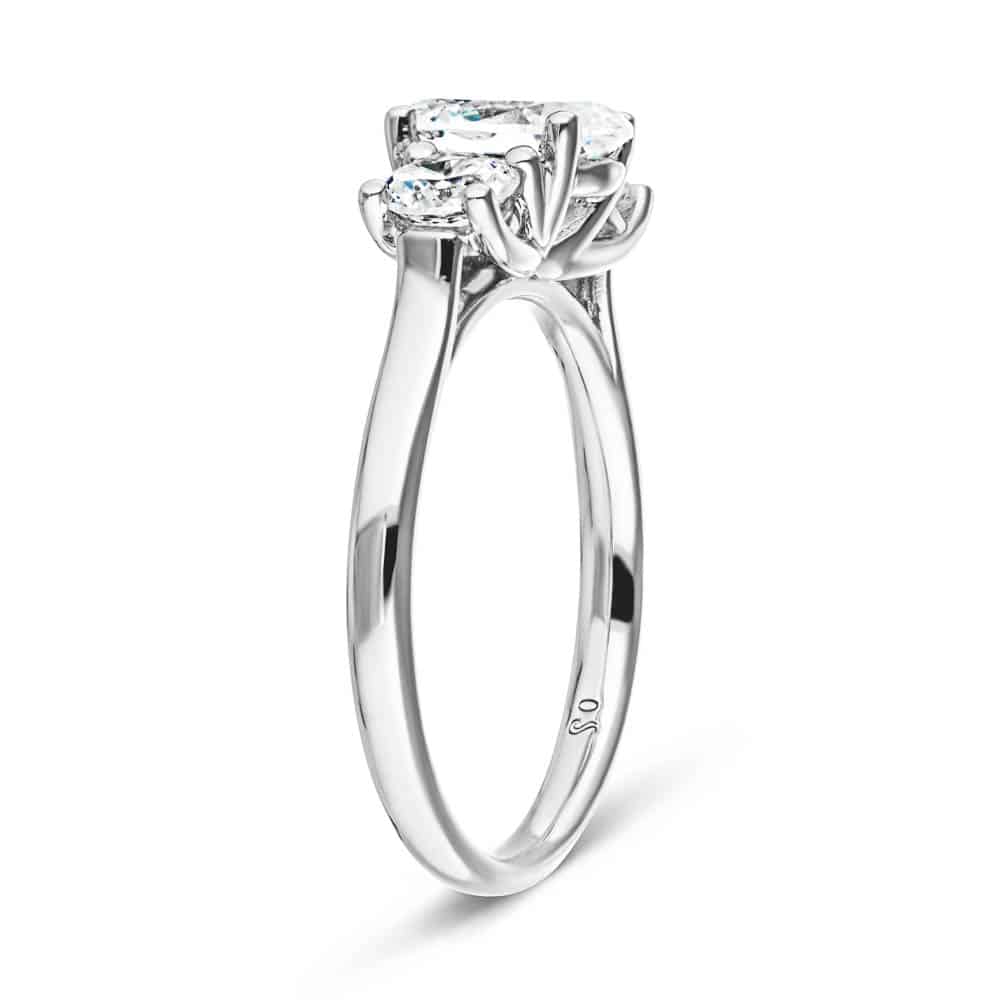 Shown with 1ct Oval Cut and Two 0.5ct Round Cut Lab Grown Diamonds in 14k White Gold|Unique three stone trellis set lab grown diamond engagement ring in white gold shown from side