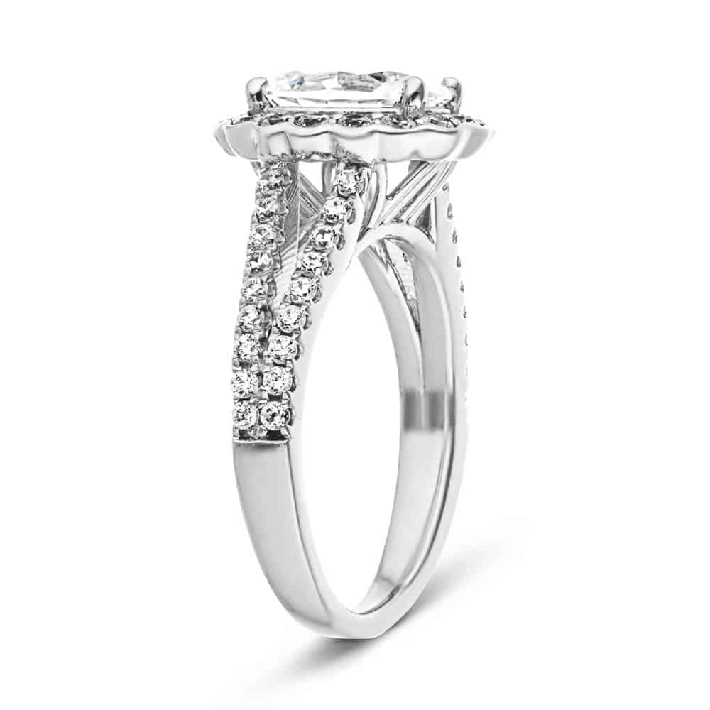 Shown with 1ct Oval Cut Lab Grown Diamond in 14k White Gold|Flower halo engagement ring with diamond accented split shank holding a 1ct oval cut lab grown diamond in 14k white gold shown from side