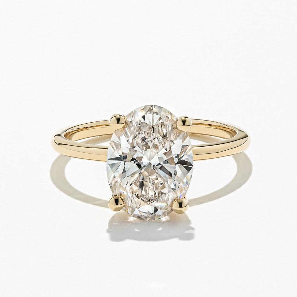 Shown with 3ct Oval Cut Lab Grown Diamond in 14k Yellow Gold|Ethical hidden halo engagement ring with 4 prong set 3ct oval cut lab grown diamond in a thin 14k yellow gold band