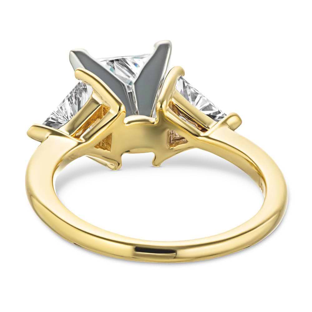 Shown with 1.5ct Princess Cut Lab Grown Diamond & 0.50ct Triangle Cut Side Stones in 14k Yellow Gold|Three stone engagement ring with 1.5ct princess cut lab grown diamond and two 0.50 triangle cut diamond side stones in 14k yellow gold shown from back
