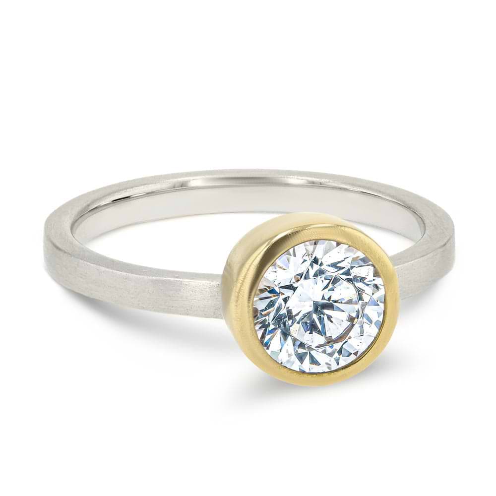 Shown in Two Toned 14K Yellow Gold and 14K White Gold with a Satin Finish|bezel set solitaire engagement ring with round cut lab grown diamond in satin finish two tone white gold and yellow gold metal