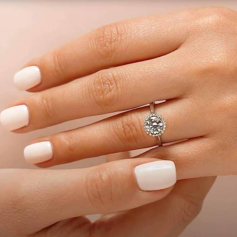 Shown with 1ct Round Cut Lab Grown Diamond in 14k White Gold|Stackable diamond halo engagement ring with a 1ct round cut lab grown diamond in 14k white gold worn on hand