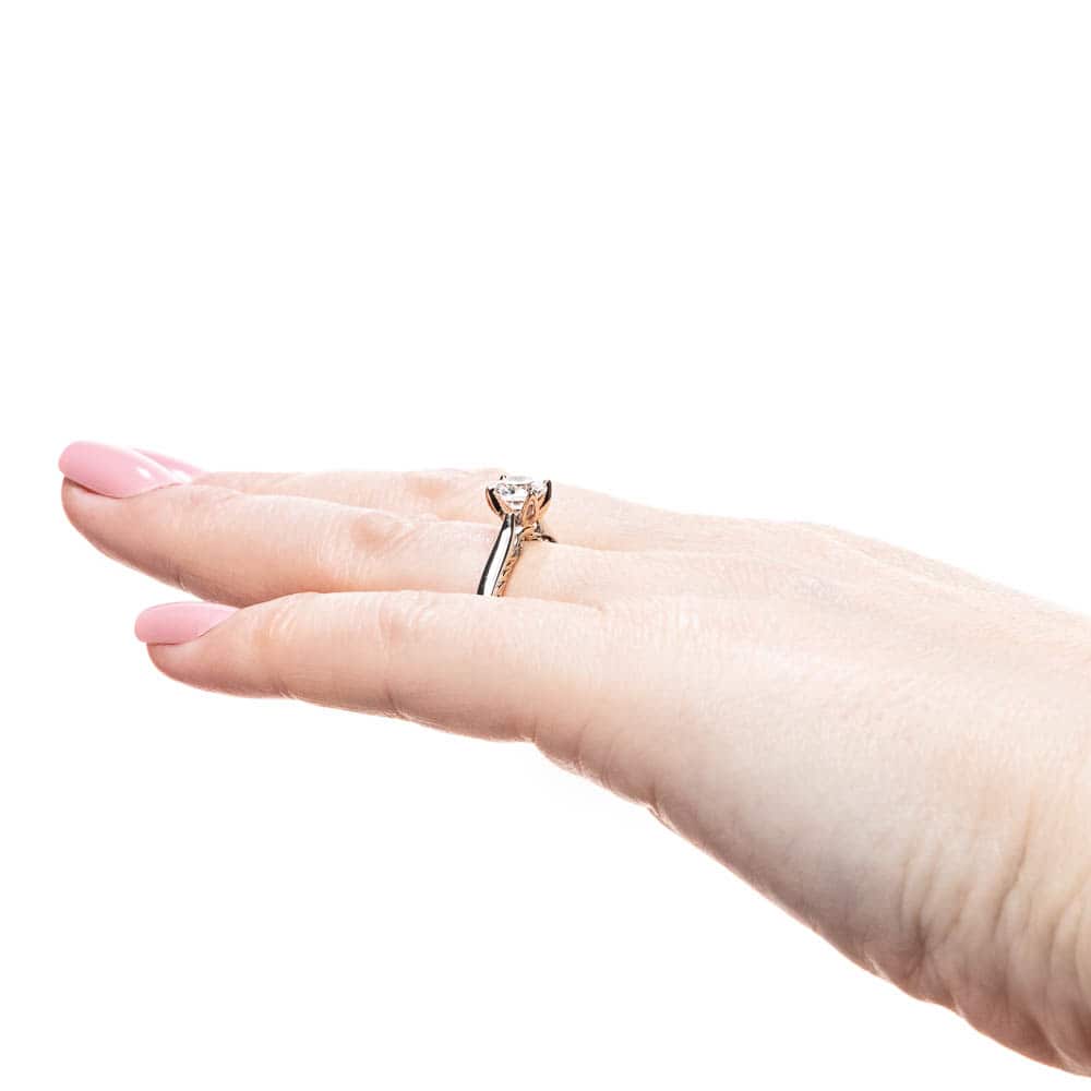 Shown with 1ct Round Cut Lab Grown Diamond in Two Tone 14k White Gold & 14k Rose Gold|Unique two tone solitaire engagement ring with inlay braided rope design set with 1ct round cut lab grown diamond in 14k white gold and rose gold worn on hand