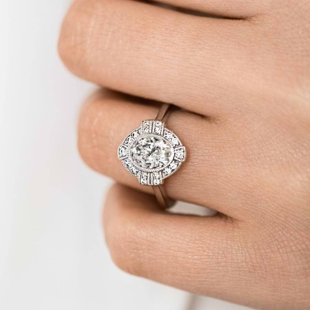 Shown with 1ct Oval Cut Lab Grown Diamond in 14k White Gold|Antique style engagement ring with milgrain detail diamond accented halo in 14k white gold shown worn on hand