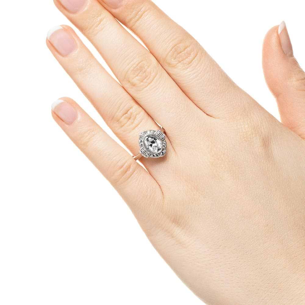 Shown with 1ct Oval Cut Lab Grown Diamond in 14k White Gold|Vintage style engagement ring with milgrain detail diamond accented halo surrounding 1ct oval cut lab grown diamond in 14k white gold shown worn on hand