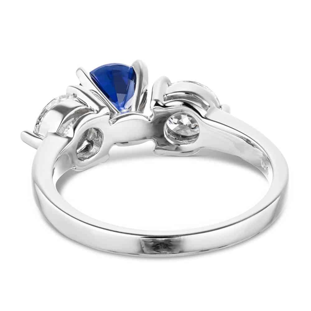 Shown with Round Cut Lab Grown Diamonds on either side of a Lab Created Blue Sapphire in 14k White Gold