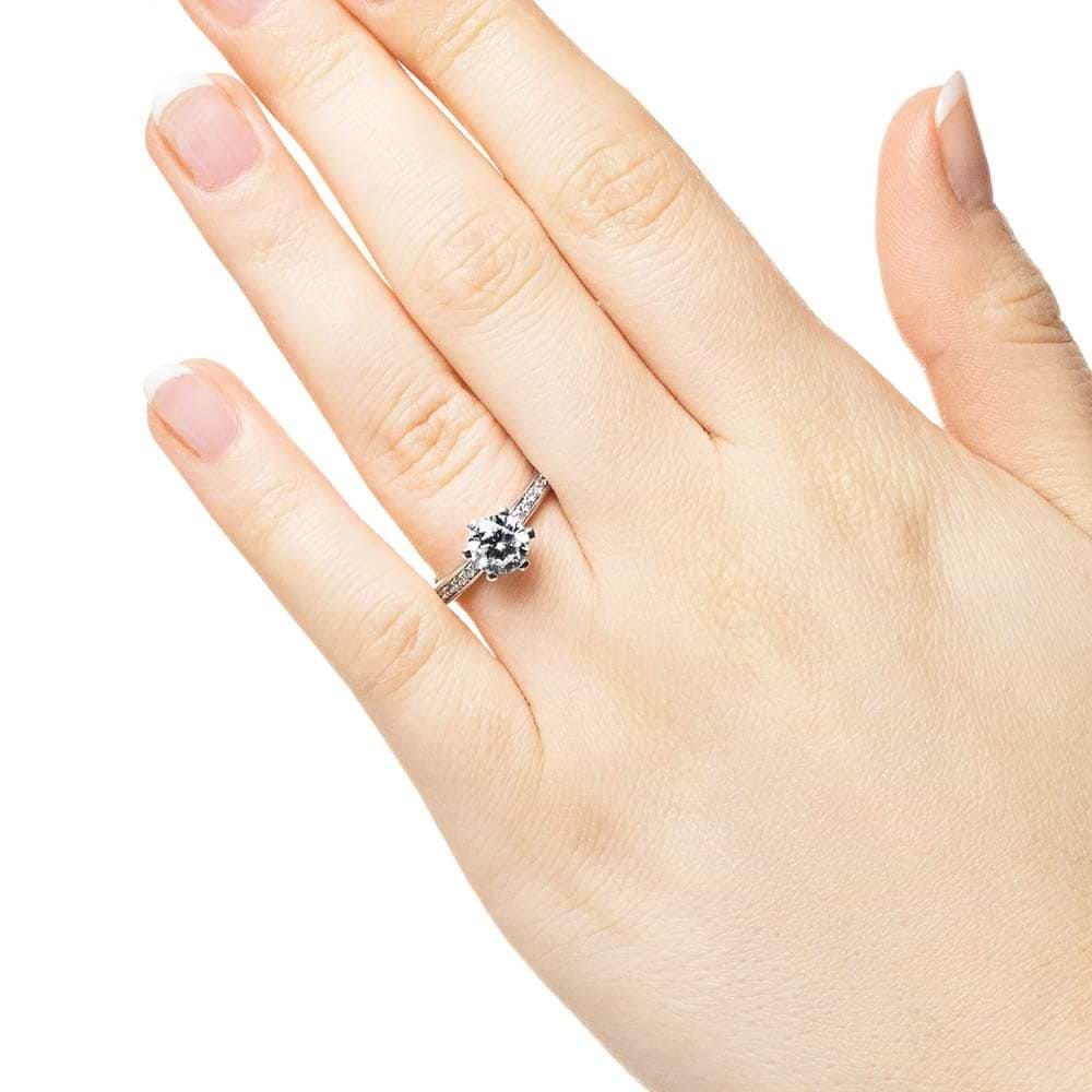 Shown with 1ct Round Cut Lab Grown Diamond in 14k White Gold|Ethical channel set diamond accented engagement ring with 1ct round cut lab grown diamond in 14k white gold worn on hand