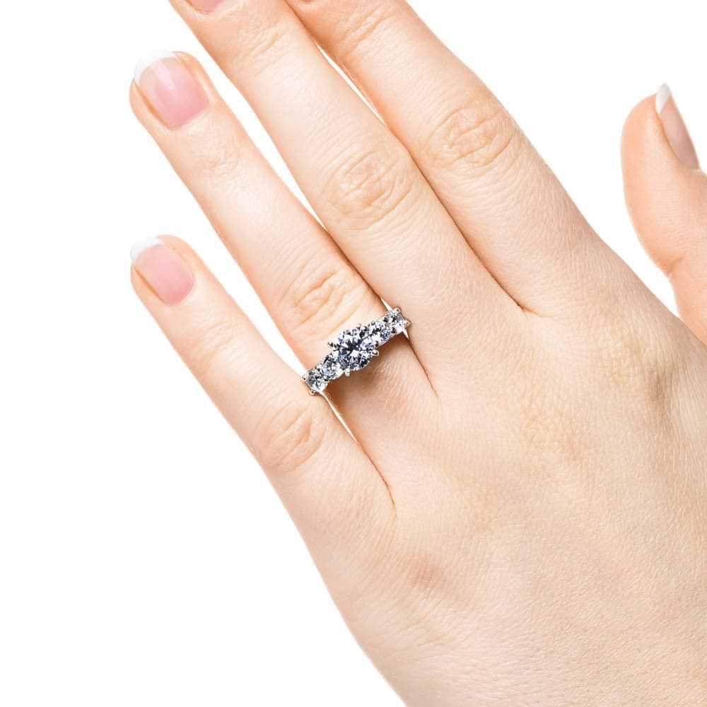 Shown with a 1ct Round Cut Lab Grown Diamond Center Stone amid four 0.25ct Diamond Hybrids in 14k White Gold|Accented engagement ring with a 1ct round cut lab grown diamond amid diamond hybrid simulants totaling 1ctw in 14k white gold worn on hand