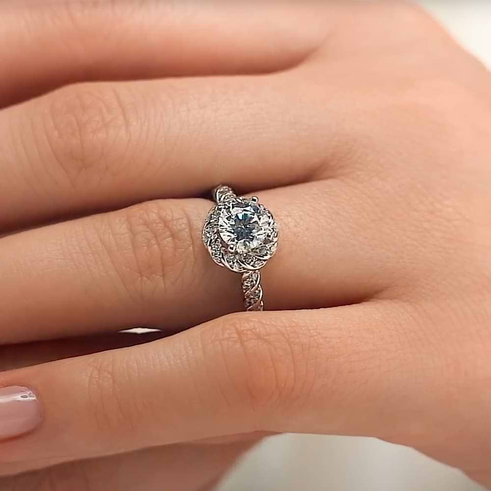 Shown with 1ct Round Cut Lab Grown Diamond in 14k White Gold|Beautiful unique twisted diamond halo engagement ring with a 1ct round cut lab grown diamond in 14k white gold worn on hand