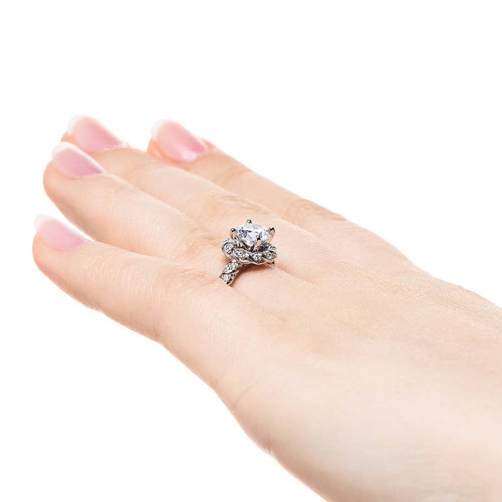 Shown with 1ct Round Cut Lab Grown Diamond in 14k White Gold|Twisted diamond halo engagement ring with a 1ct round cut lab grown diamond in 14k white gold worn on hand sideview