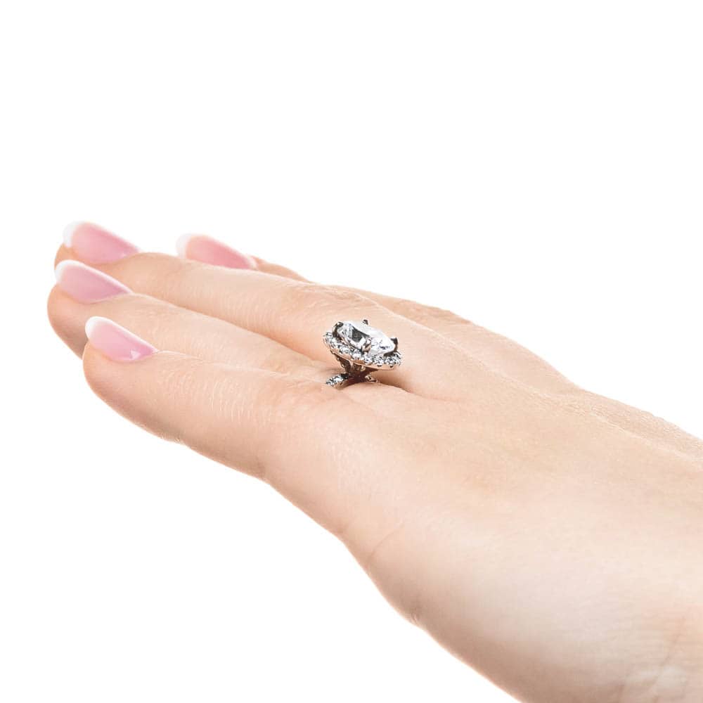 Shown with 1ct Oval Cut Lab Grown Diamond in Platinum|Dream diamond halo engagement ring with diamond accents and a 1ct oval cut lab grown diamond in platinum worn on hand sideview