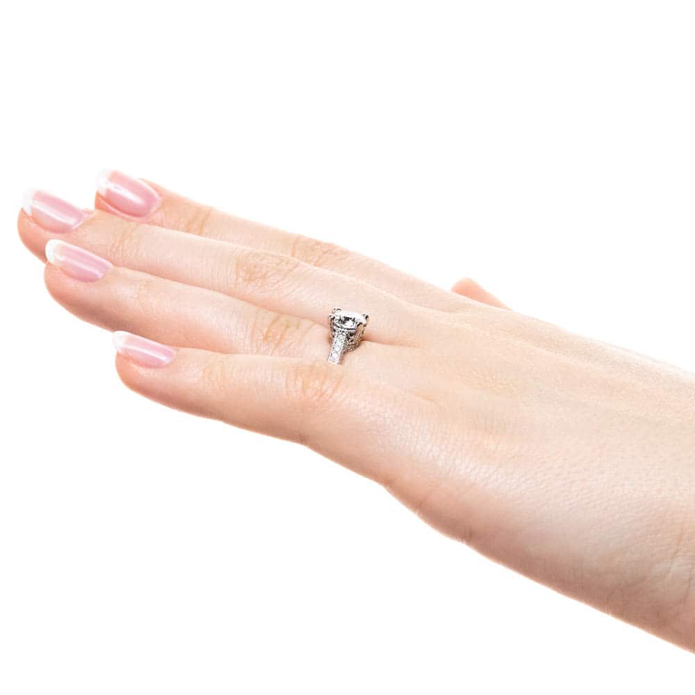 Shown with 1ct Round Cut Lab Grown Diamond in 14k White Gold|Antique style diamond accented engagement ring with 1ct round cut lab grown diamond in 14k white gold filigree detailed band worn on hand sideview