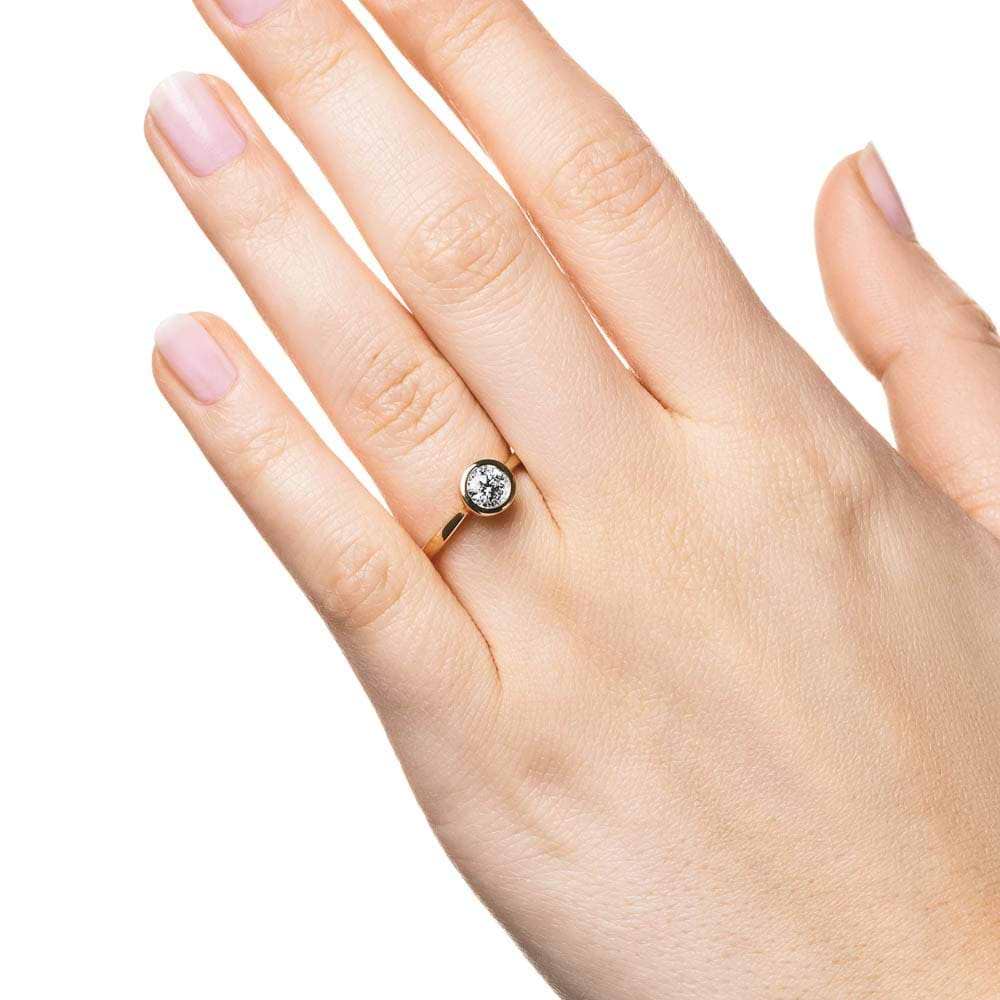 Shown with 1ct Round Cut Lab Grown Diamond in 14k Yellow Gold|Modern engagement ring with 1ct round cut bezel set lab grown diamond in 14k yellow gold worn on hand