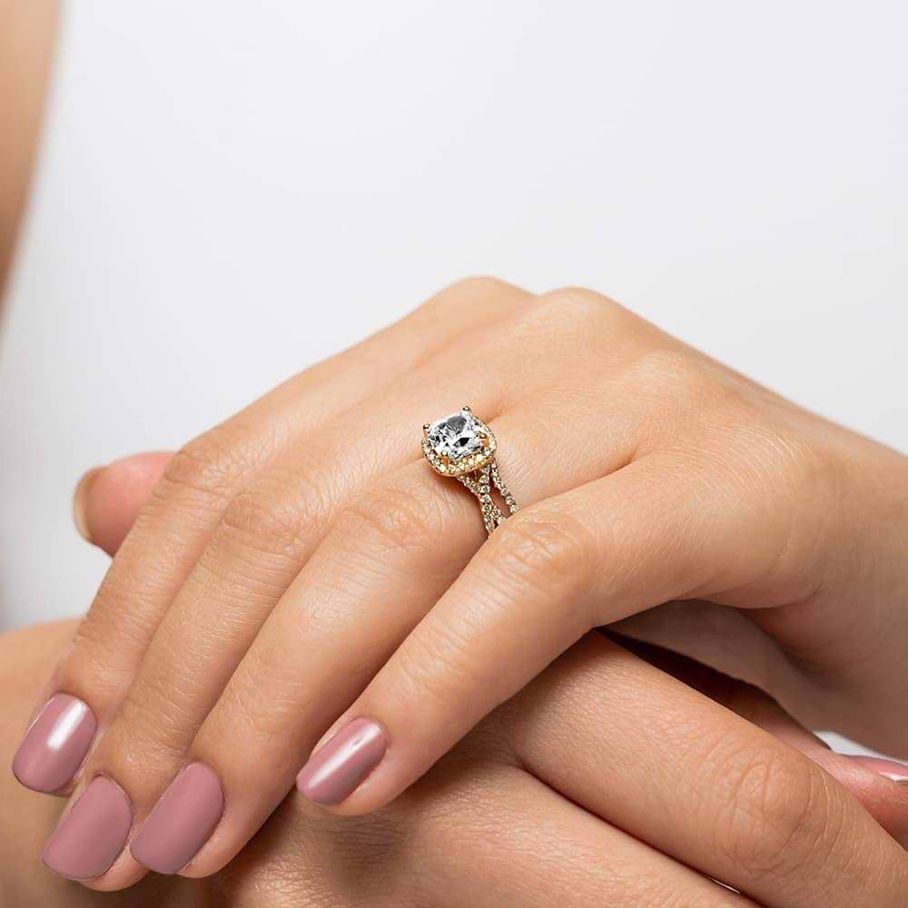 Eternal Monogram Wedding Set shown in recycled 14K yellow gold featuring a cushion cut center stone surrounded by a halo of recycled diamonds continuing down the shank with matching wedding band | eternal monogram wedding set recycled diamonds engagement ring wedding band