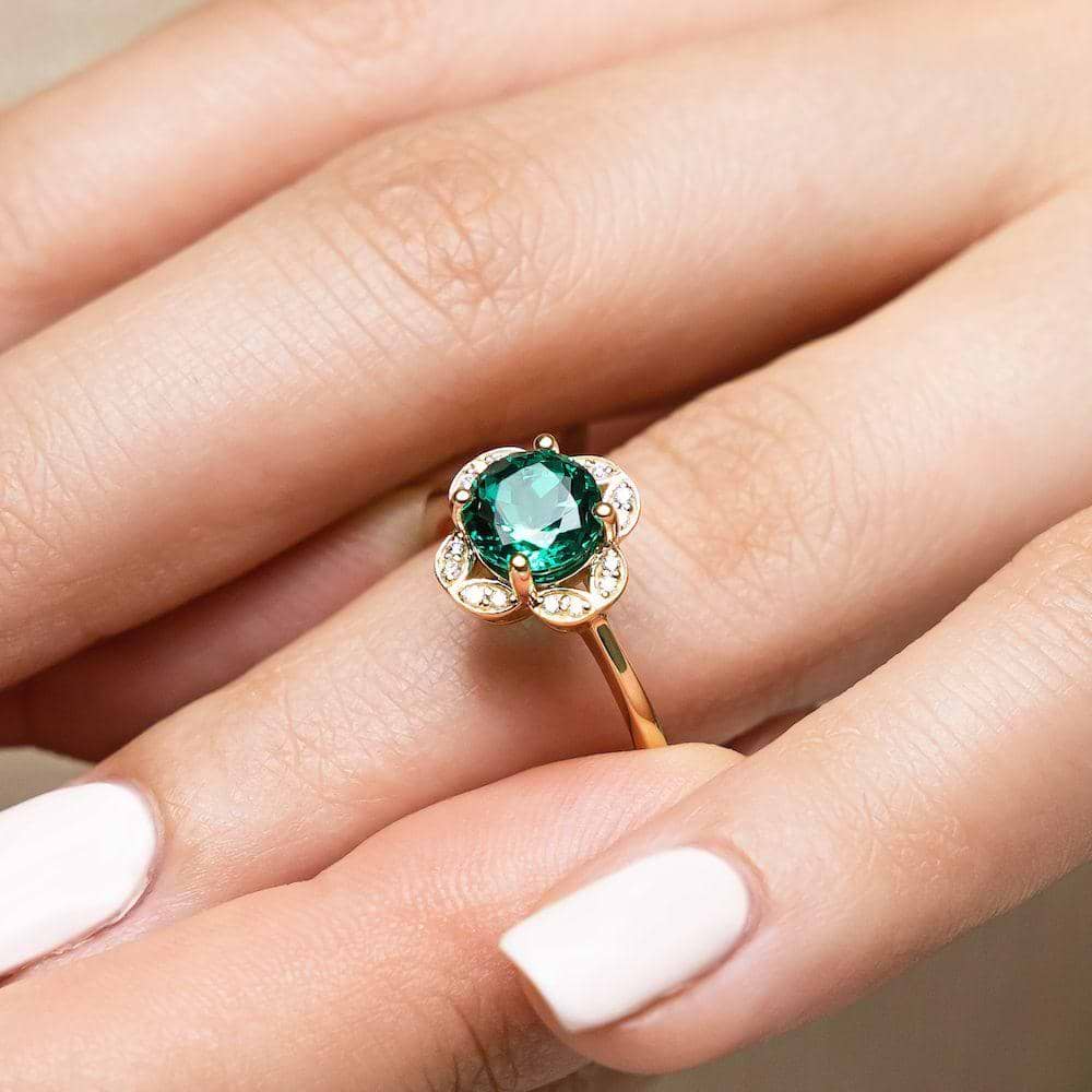 Shown with 1ct round cut lab created emerald in 14k yellow gold|Nature inspired vintage style engagement ring with floral petal halo design around a 1ct round cut lab created emerald in 14k yellow gold