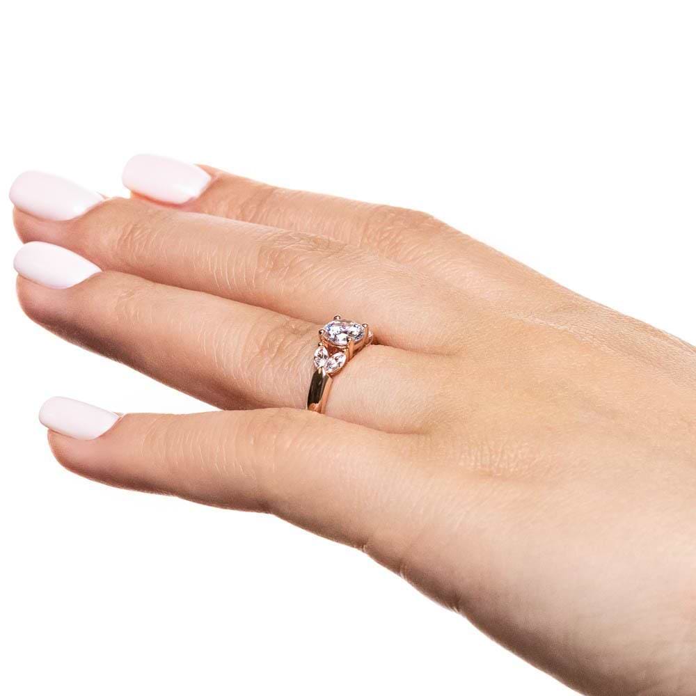 Shown with 0.75ct Round Cut Lab Grown Diamond Center in 14k Rose Gold|Diamond accented engagement ring with 0.75ct round cut lab grown diamond center and 4 marquise cut side stones in 14k rose gold shown worn on hand sideview