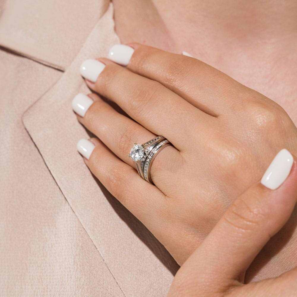Shown with a 1.0ct Round cut Lab Grown Diamond with channel set diamond accented band with matching wedding band in recycled 14K white gold | wedding set Shown with a 1.0ct Round cut Lab Grown Diamond with channel set diamond accented band with matching wedding band in recycled 14K white gold