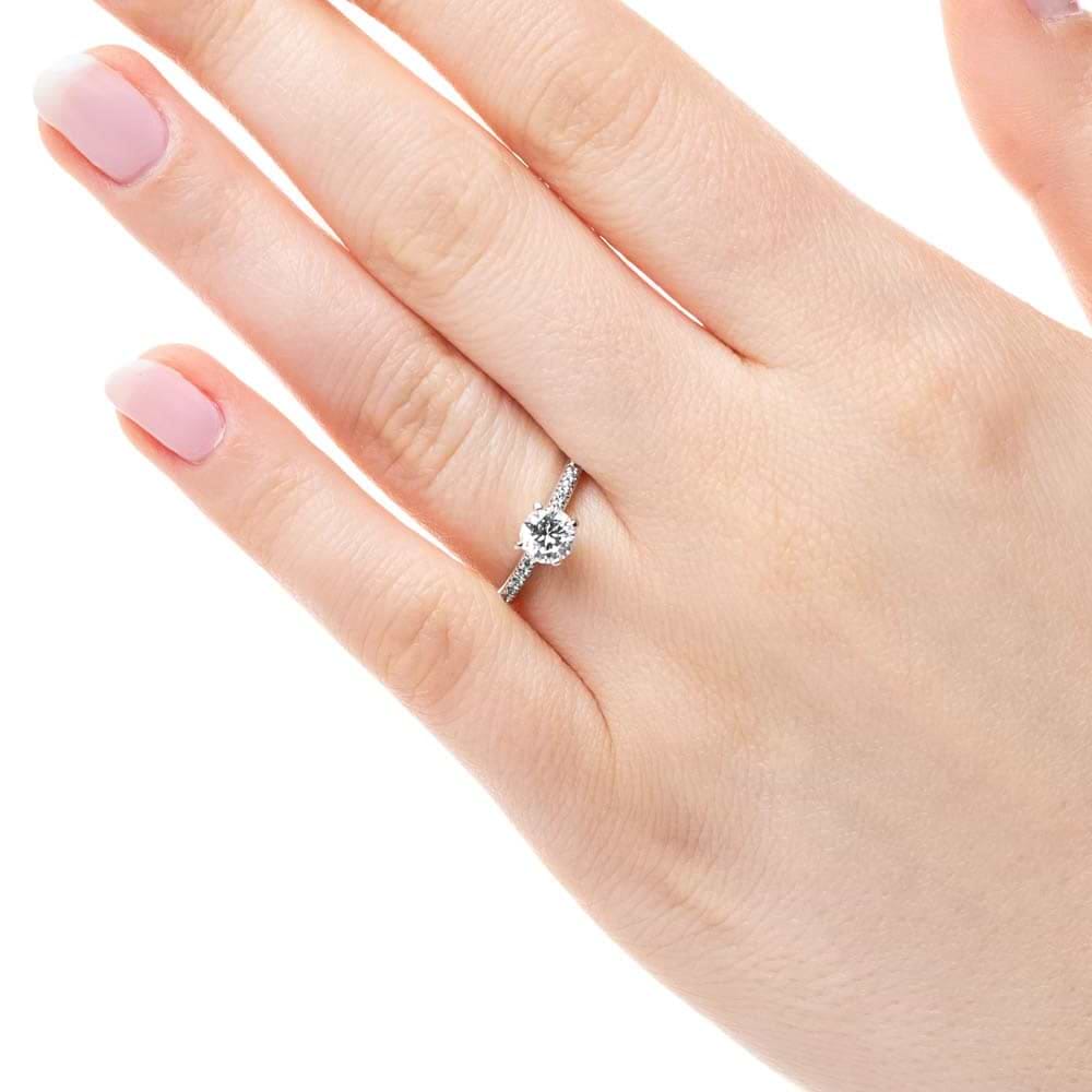 Shown with 0.70ct Round Cut Lab Grown Diamond in 14k White Gold|Diamond accented solitaire engagement ring with 4 prong set round cut lab grown diamond in 14k white gold worn on hand