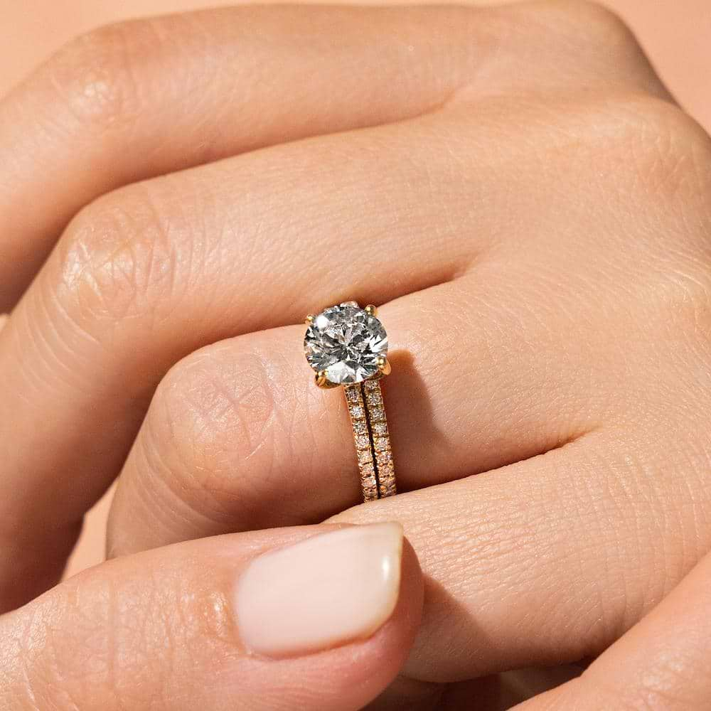 Shown with a 2.0ct Round cut Lab-Grown Diamond with a diamond accented band in recycled 14K yellow gold with matching wedding band 