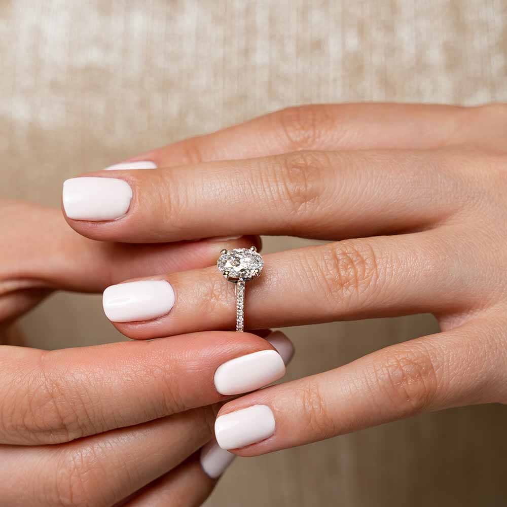 Shown with 1ct Oval Cut Lab Grown Diamond in 14k White Gold|Ethical diamond accented engagement ring with 1ct oval cut lab grown diamond in 14k white gold worn on hand