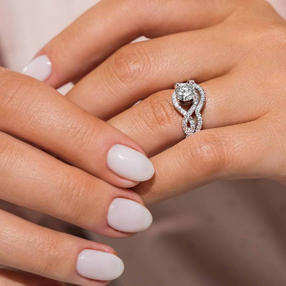 Shown with a 1.0ct Round cut Lab-Grown Diamond with infinity style diamond accented band with matching wedding band | wedding set Shown with a 1.0ct Round cut Lab-Grown Diamond with infinity style diamond accented band with matching wedding band