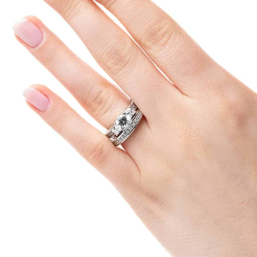Shown with a Round cut center stone and two Princess cut Lab-Grown Diamonds side stones with scroll detailing and accenting diamonds on the band in recycled 14K white gold | three stone engagement ring Shown with round cut center stone and two Princess cut Lab-Grown Diamonds with scroll detailing and accenting diamonds on the band in recycled 14K white gold with matching wedding band
