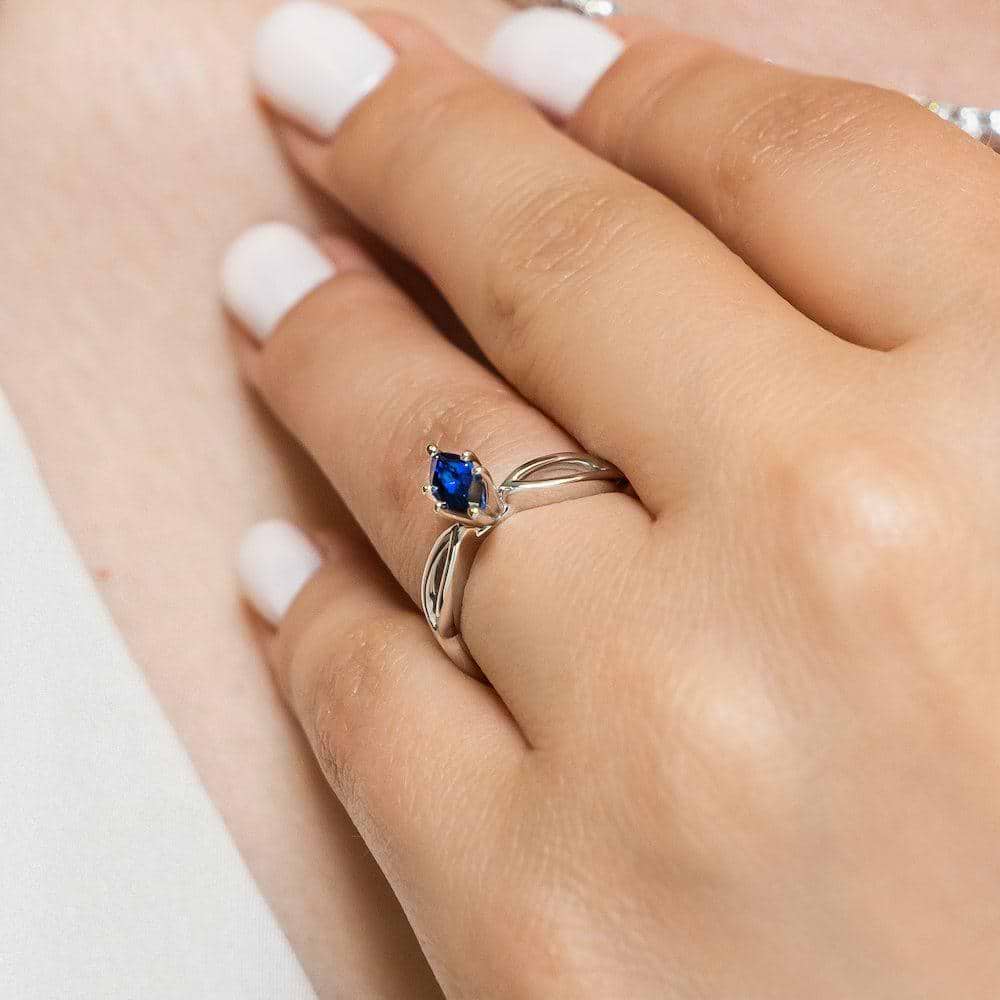 Shown with 1ct Marquise Cut Lab Grown Blue Sapphire in 14k White Gold|Unique nature inspired solitaire engagement ring with a 1ct marquise cut lab grown blue sapphire in twisted metal design 14k white gold band worn on hand
