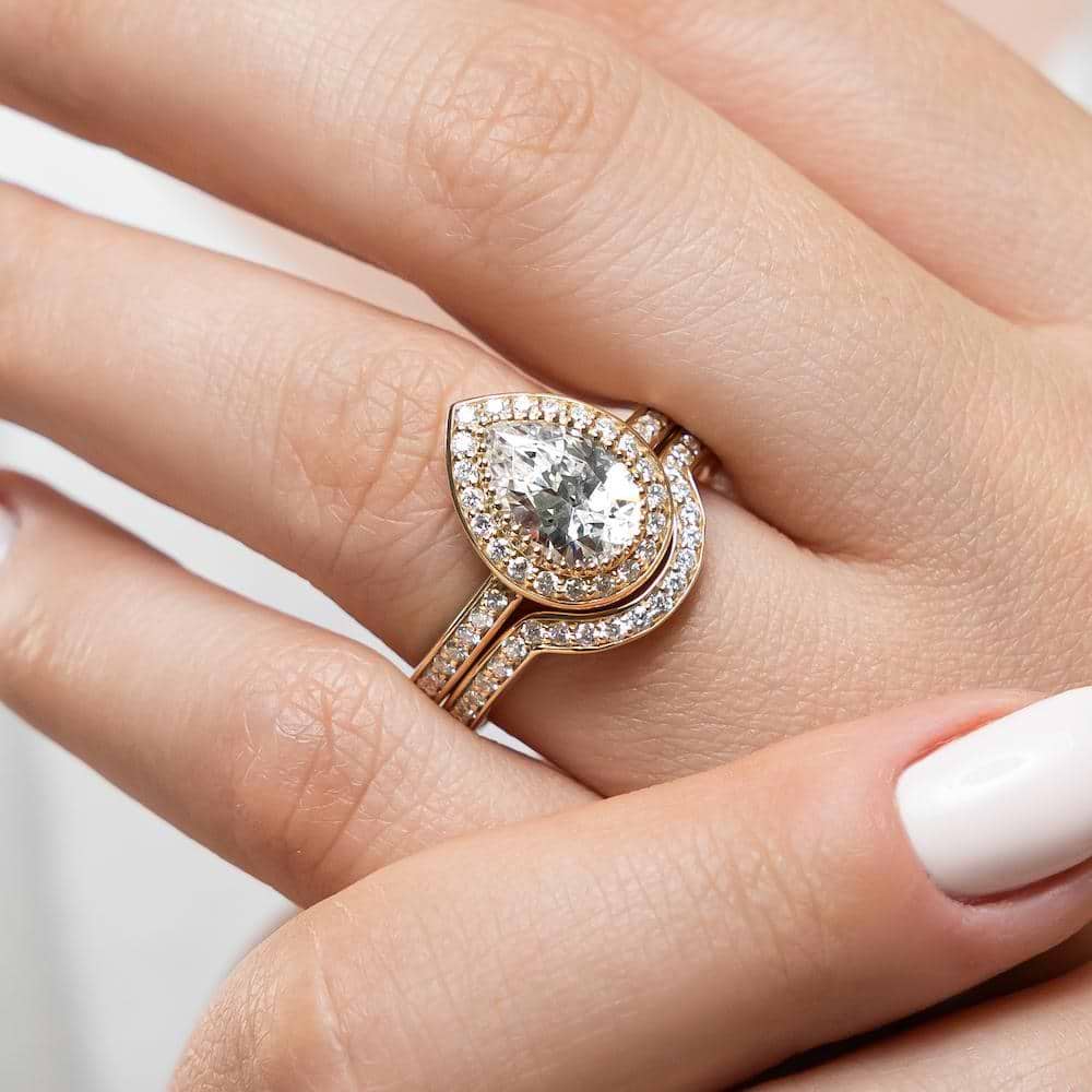 Shown with a 1.0ct Pear cut Lab-Grown Diamond with a diamond accented halo and band in recycled 14K yellow gold with matching wedding band | french engagement ring Shown with a 1.0ct Pear cut Lab-Grown Diamond with a diamond accented halo and band in recycled 14K yellow gold matching wedding band