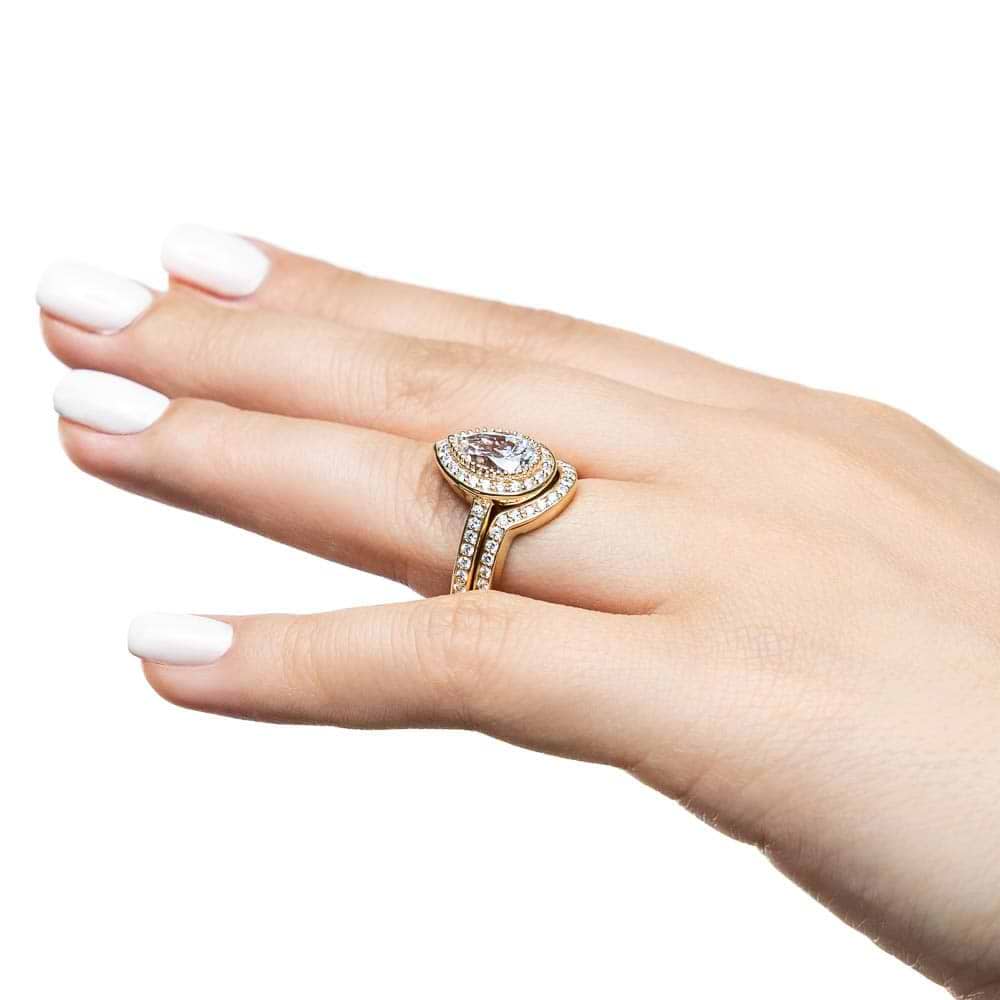 Shown with a 1.0ct Pear cut Lab-Grown Diamond with a diamond accented halo and band in recycled 14K yellow gold with matching wedding band | french engagement ring Shown with a 1.0ct Pear cut Lab-Grown Diamond with a diamond accented halo and band in recycled 14K yellow gold matching wedding band