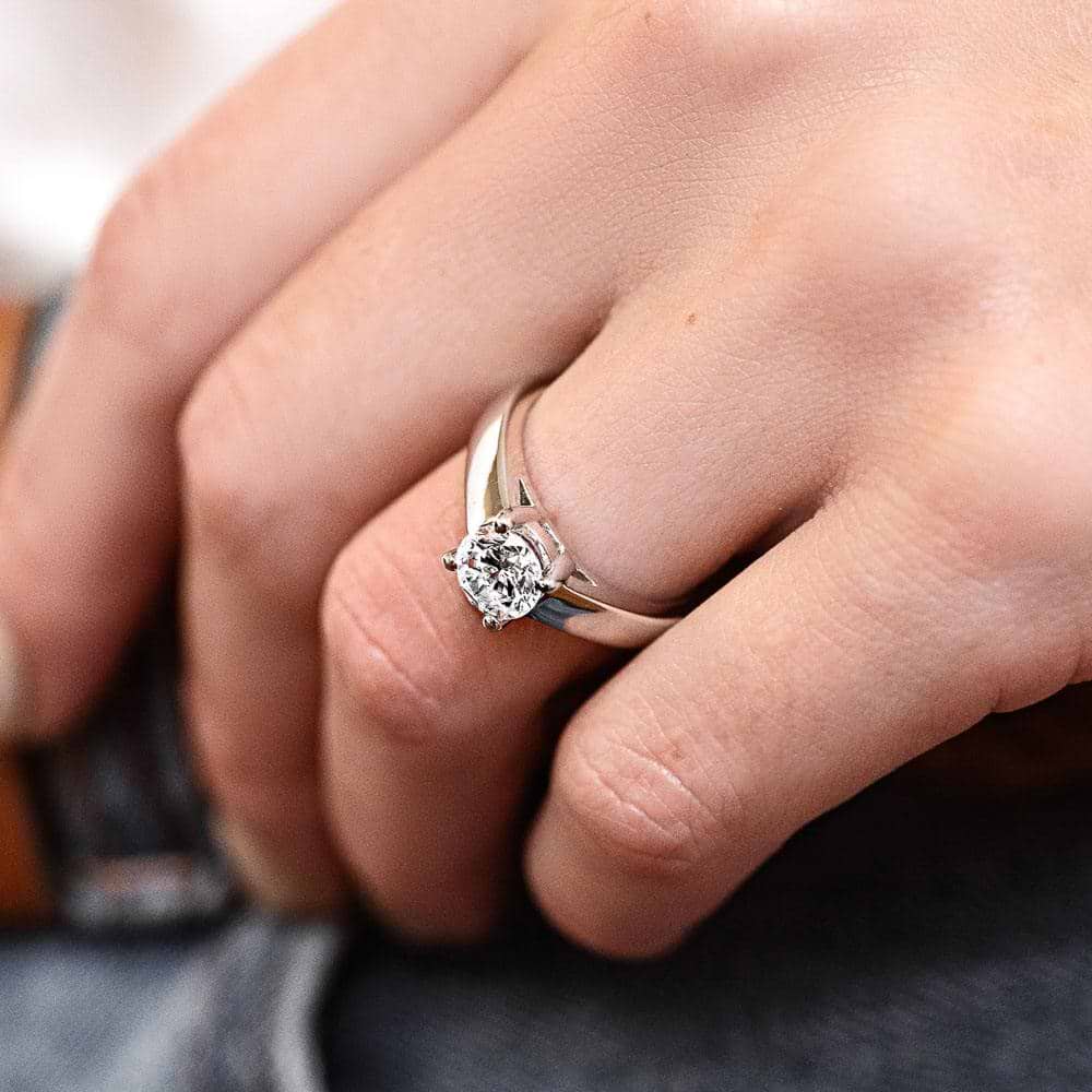 Shown with 1ct Round Cut Lab Grown Diamond in 14k White Gold|Traditional trellis set solitaire engagement ring with 1ct round cut lab grown diamond in 14k white gold wide band worn on hand