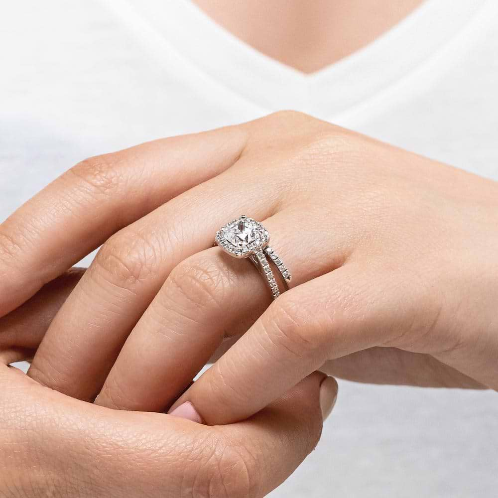 Shown with a 1.0ct Cushion cut Lab-Grown Diamond with a diamond accented halo and diamonds accenting the band in recycled 14K white gold with matching band, purchase the set for a discount 