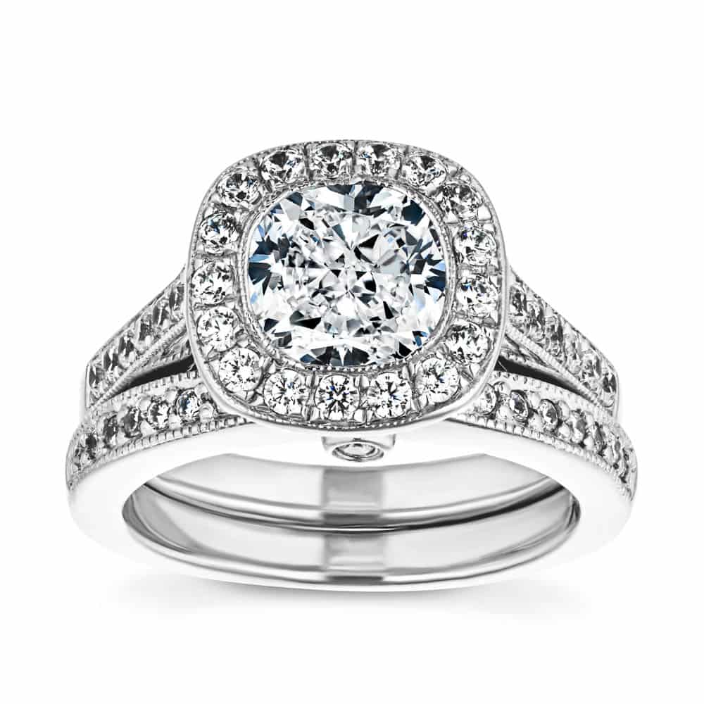 Shown with a 1.0ct Cushion cut Lab-Grown Diamond with a diamond accented and filigree detailed halo and accenting diamonds on the band in recycled 14K white gold with matching band, purchase the set together for a discount 