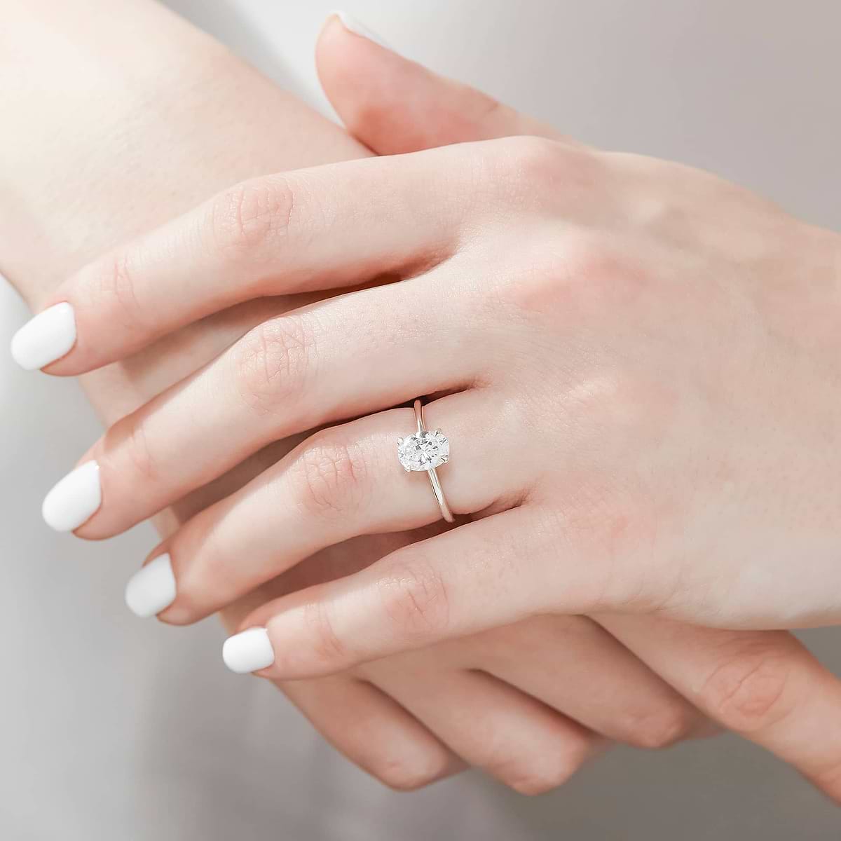 Shown with 1ct Oval Cut Lab Grown Diamond in 14k White Gold|Classic solitaire engagement ring with 1ct oval cut lab grown diamond in 14k white gold band shown worn on hand